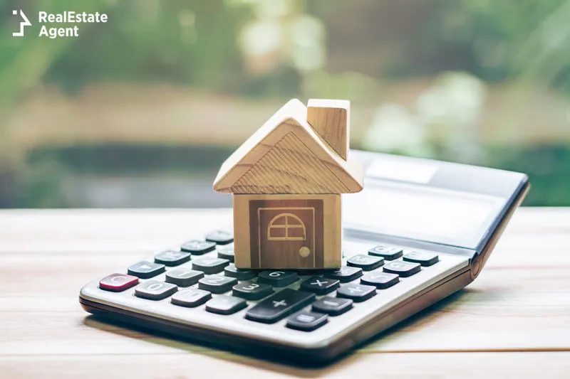 a house of wooden above a calculator