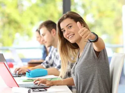 happy teenager girl in collage taking notes on laptop