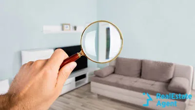 man holding a magnifying glass and checking the room