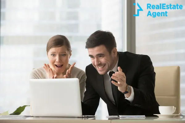 woman and man looking very excited at the laptop screan